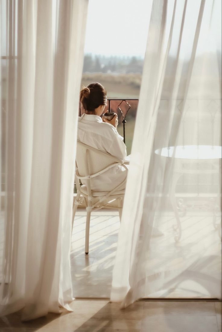 Morning light, white robe and coffee by sheer curtains
